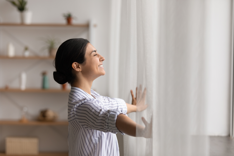 Happy hindu woman open window drapes close eyes in delight - stock photo
Bathing in sunlight. Excited young indian lady meet first morning at new flat house part curtains enjoy being homeowner. Happy hindu female open drapes on window breath fresh air close eyes in delight