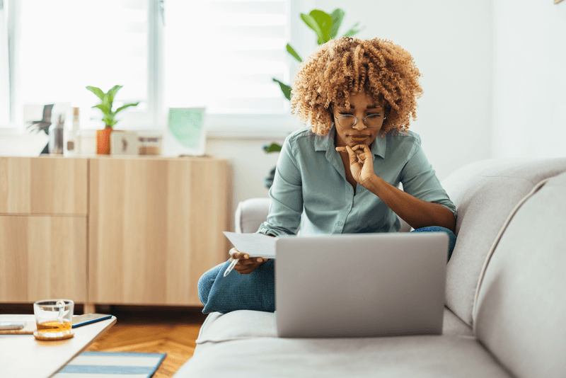 woman sitting on couch with laptop