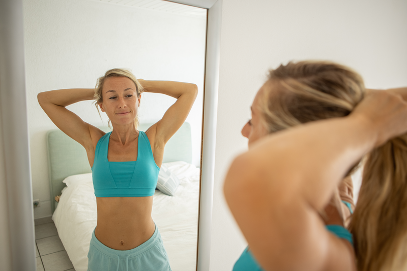 Young woman checking herself in the mirror - stock photo
body conscious