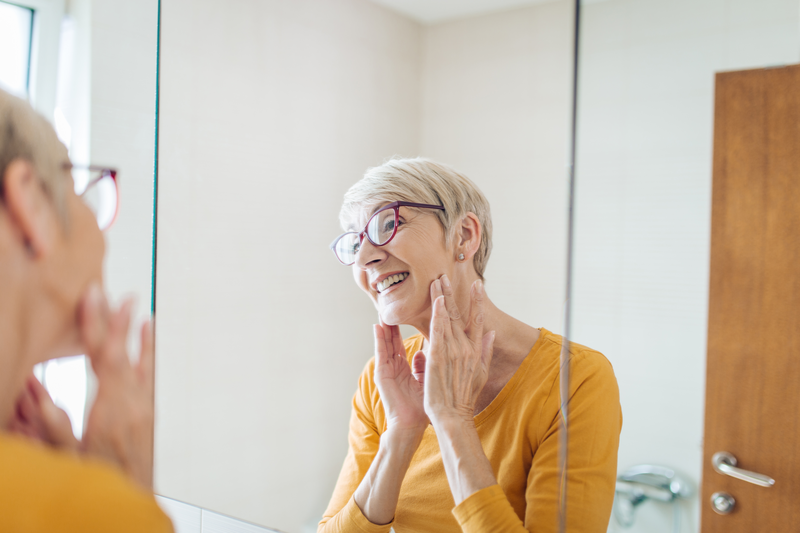 Senior woman taking care of her face skin beauty - stock photo
Beautiful senior woman nourishing her face skin in the bathroom.