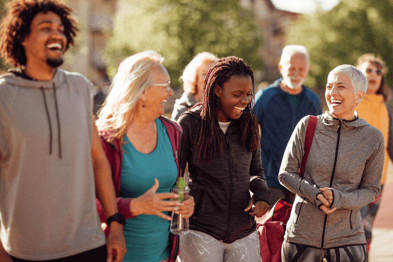 Group of smiling people in the community walking outdoors