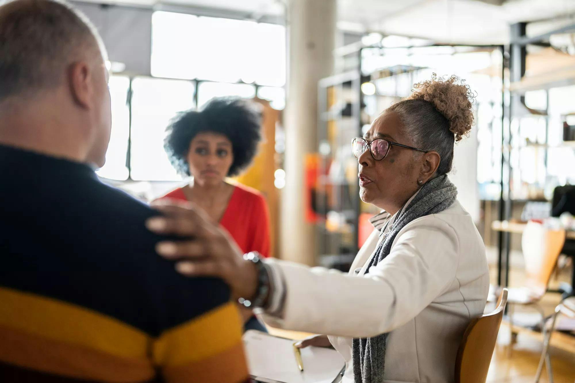 Senior woman comforting a mature man in group therapy at a coworking - stock photo
Senior woman comforting a mature man in group therapy at a coworking