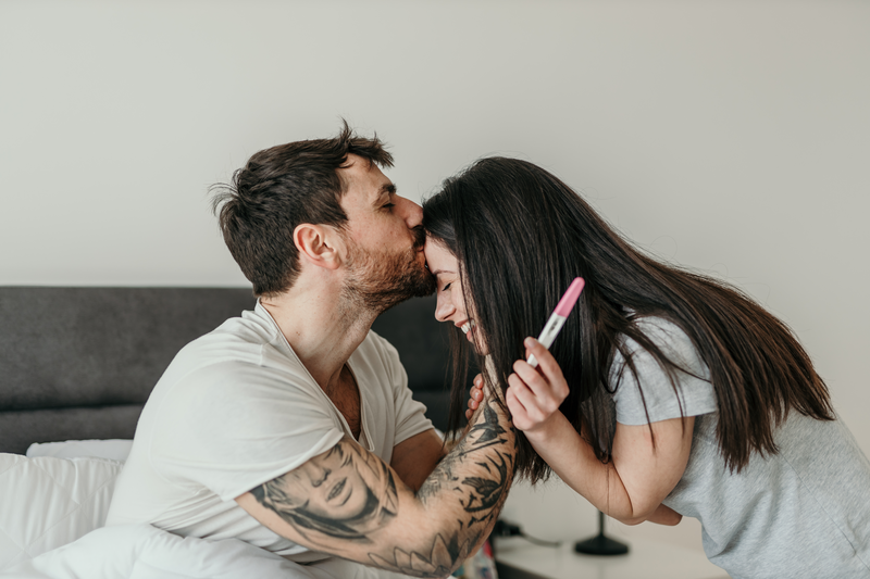 I love you now more than ever - stock photo
Shot of a husband and pregnant wife holing a positive pregnancy test, kissing, and sitting together in a bedroom.